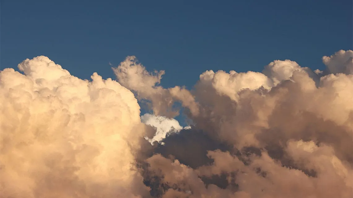 Beleuchtete Wolkenwand vor blauem Himmel – Beitragsbild zum Evergreen Marktkommentar August 2026