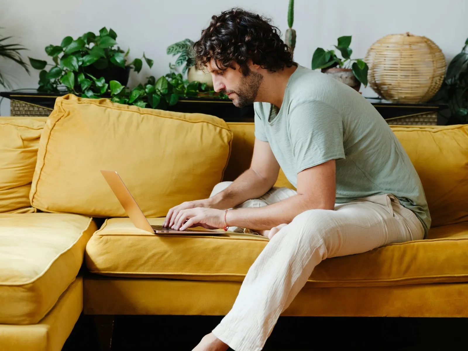 Ein Mann sitzt mit einem Laptop auf der Couch und wechselt entspannt sein VL-Depot.